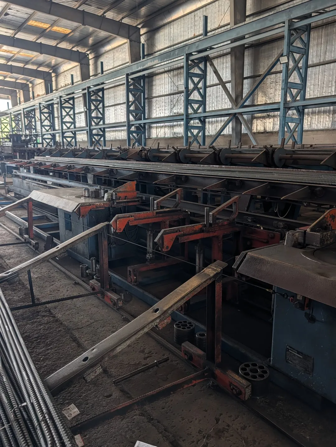 Rebar bending line at the Dubar factory, with straight bars on the feed rack and bending heads at each end